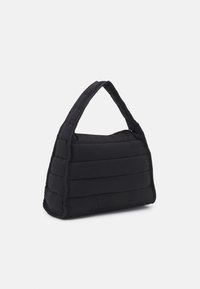 Sac à main noir matelassé avec une forme structurée et une seule bandoulière, comportant des panneaux texturés et une fermeture éclair.