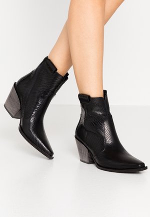 Czarne botki do kostki z teksturowanej sztucznej skóry, z ostrym noskiem i niskim, piętrowym obcasem. Z boku zamek błyskawiczny i elastyczne wstawki.