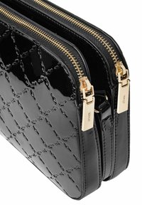 Czarna torebka z lakierowanej skóry, z pikowanym wzorem, dwoma przegródkami oraz złotymi zamkami i elementami metalowymi. Gładka tekstura, zorganizowany design.