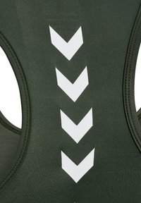 Canotta atletica verde oliva con motivo a zigzag bianco sul retro. Realizzata in un tessuto morbido ed elastico con scollatura rotonda.