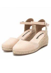 Sandalias de cuña beig con una correa de tobillo texturizada, una puntera lisa y detalles de yute alrededor de la suela. Diseñadas con una plantilla acolchada.
