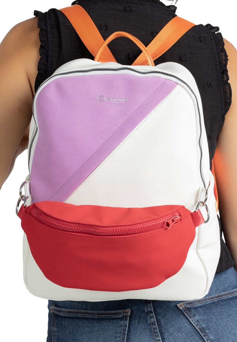 Rucksack aus weißem strukturiertem Material, mit einem diagonalen lavendelfarbenen Paneel und einer roten Reißverschlusstasche. Orangefarbene Träger und Logodetails sichtbar.