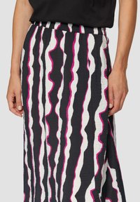 Zwarte rok met witte en roze golvende strepen; gemaakt van gestructureerde stof; heeft een elastische tailleband.