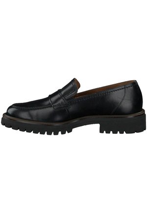 Schwarzer Leder-Schlupfschuh mit einer gerundeten Spitze, kontrastierenden Nähten und einer dicken Gummisohle mit einem Rillenmuster. Akzentuiert mit einem dezenten Riemen.