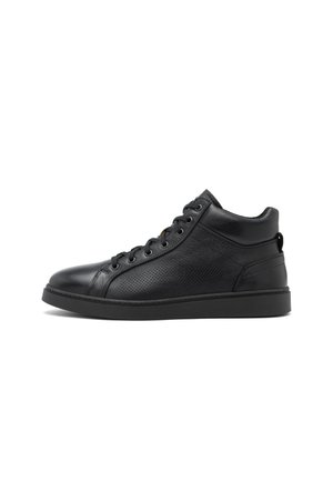 Zapatilla alta de cuero negro con paneles laterales perforados, cordones negros, cuello acolchado y suela plana de goma, mostrada de perfil sobre un fondo blanco.