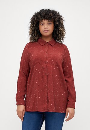 Chemise boutonnée bordeaux à manches longues, avec col et motif de pois blancs. Comprend deux poches poitrine et une texture lisse.