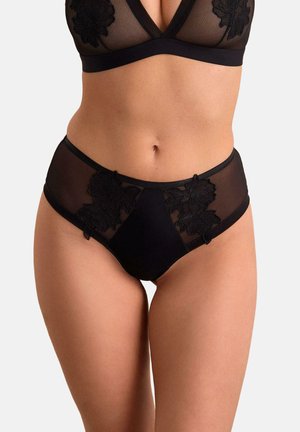 Czarny, prześwitujący komplet bielizny z kwiatowym haftem na miseczkach biustonosza i majtkach z wysokim stanem, noszony przez modelkę na neutralnym tle.