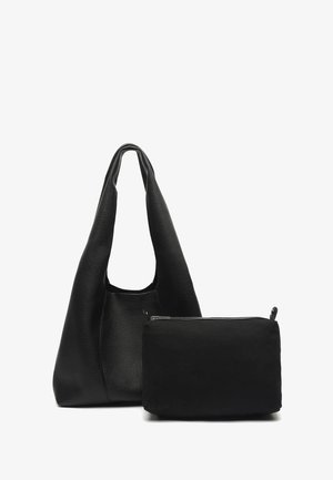 Weiche schwarze Leder-Schultertasche mit breitem Riemen neben einem kleineren schwarzen Reißverschluss-Etui vor weißem Hintergrund.