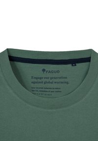 T-shirt in cotone riciclato verde con collo a giro, caratterizzato da accenti navy e testo stampato all'interno riguardante la responsabilità ambientale.