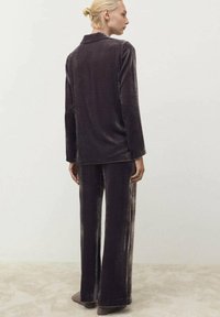 Viskose-Loungewear-Set in Dunkelgrau; langärmliges Hemd mit Kragen kombiniert mit weit geschnittenen Hosen, mit einer weichen, strukturierten Oberfläche.