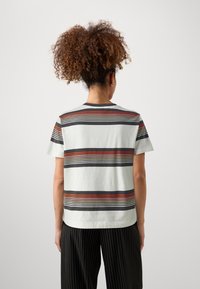 Hvid stribet t-shirt med vandrette røde, orange og sorte linjer; korte ærmer, rund halsudskæring og blød bomuldsstruktur.