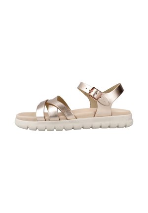 Sandalias metálicas en color oro rosa con tiras entrelazadas y hebilla ajustable en el tobillo. Suela flexible de color claro con detalles texturizados.