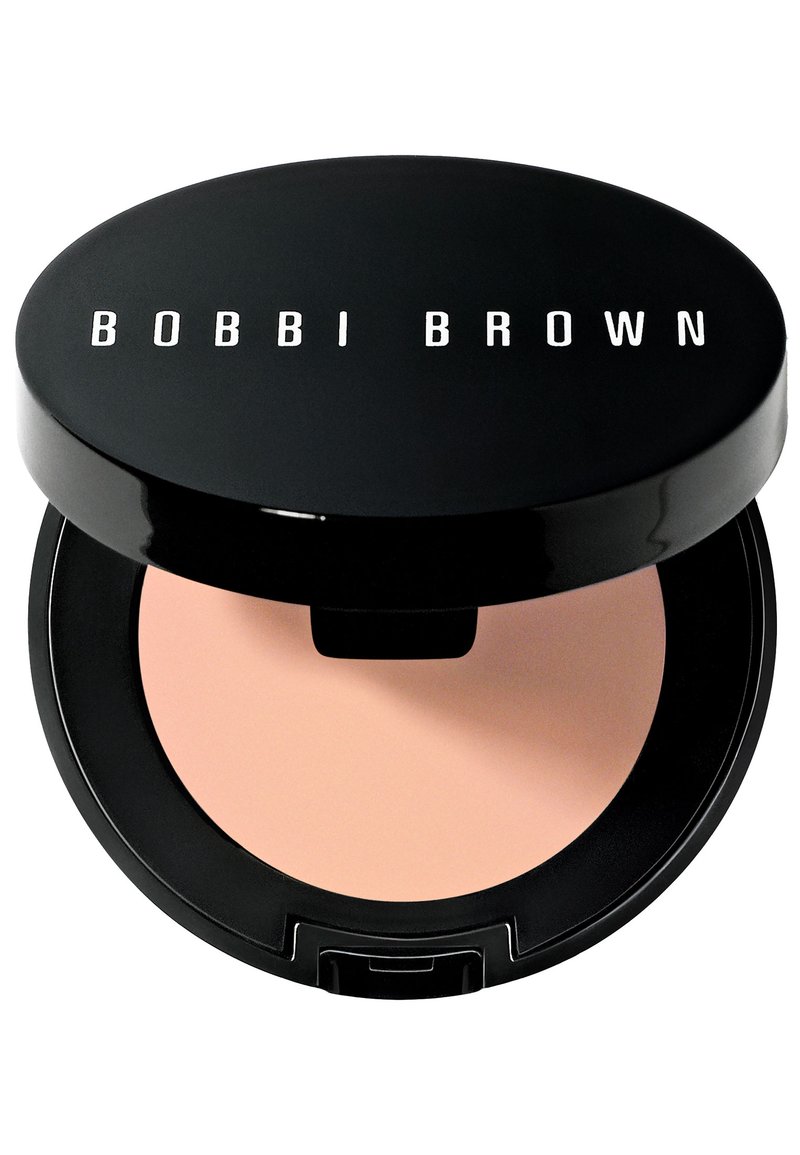 Compatto nero con finitura lucida e testo bianco "BOBBI BROWN." All'interno contiene una polvere liscia beige. Include una piccola indentazione per un'apertura facile.