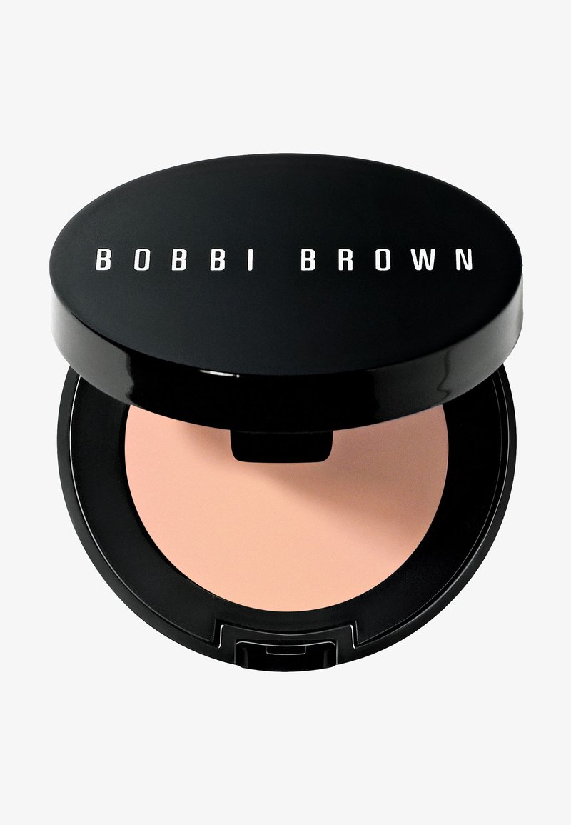 Compatto nero con finitura lucida e testo bianco "BOBBI BROWN." All'interno contiene una polvere liscia beige. Include una piccola indentazione per un'apertura facile.
