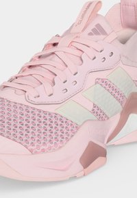 Ροζ παπούτσι τρεξίματος Adidas με επάνω μέρος από διχτυωτό υλικό, επενδυμένο κολάρο, μαλακή σόλα και τρεις λευκές ρίγες στο πλάι.