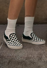 Čierne a biele kockované slip-on topánky s kontrastným zeleným akcentom, pevná gumová podrážka a polstrovaný golier pre pohodlie.