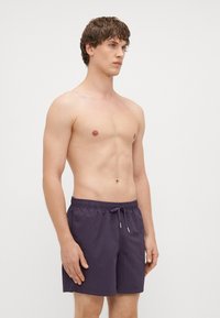 Fioletowe szorty do pływania wykonane z lekkiego materiału, z elastyczną talią i sznurkiem ściągającym oraz prostą, gładką fakturą.