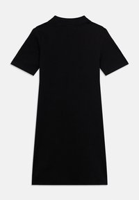 Μαύρο πόλο φόρεμα με κοντά μανίκια από βαμβάκι. Διαθέτει κλασικό γιακά και σχέδιο μήκους μέχρι το γόνατο με ομαλή υφή. Χωρίς ορατά σχέδια ή διακοσμήσεις.