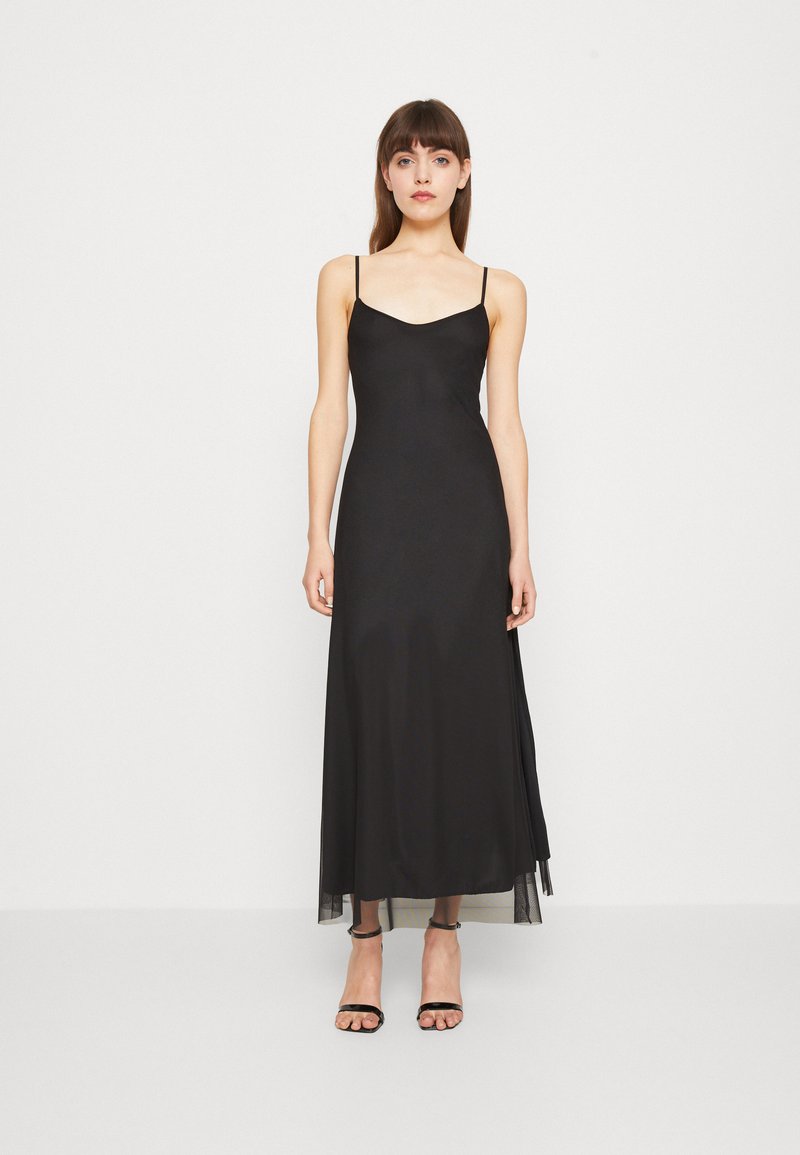 Black, sleeveless maxi dress with a fitted bodice and sheer layered hem. Smooth fabric with a subtle sheen, minimalistic design, and no visible patterns.