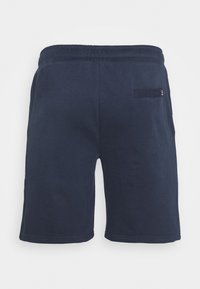 Short en coton bleu marine avec taille élastique et une seule poche arrière avec une petite étiquette logo sur le côté droit.