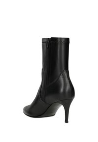 Stivale alla caviglia in pelle nera con chiusura a zip, punta affilata e tacco a stiletto. Presenta una texture liscia e dettagli di cucitura lungo la parte superiore.