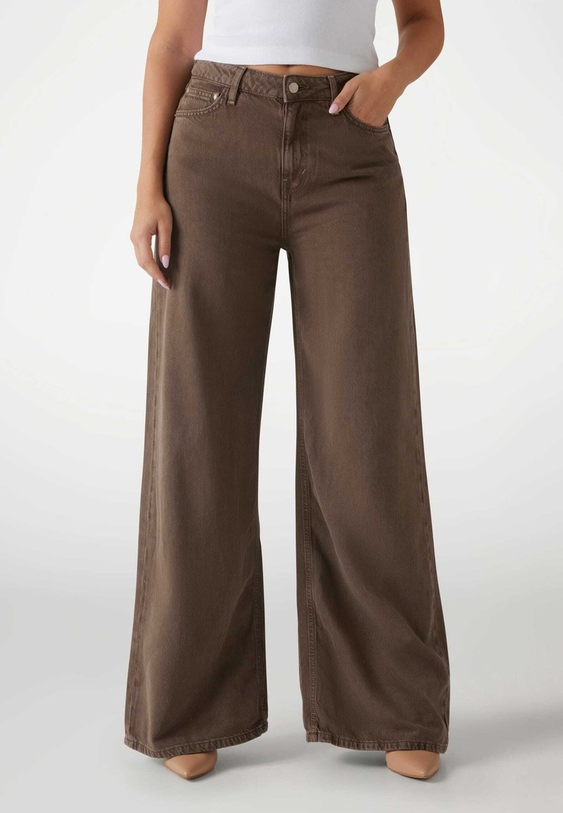 Jeans de pernera ancha en color marrón, elaborados con denims duraderos, que presentan una cintura alta, bolsillos delanteros y detalles de costura sutiles en los bolsillos.