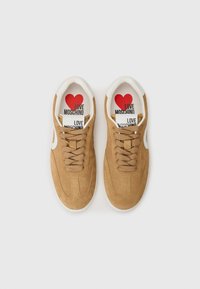 Rudi zomšo batai su baltais akcentais ir raišteliais. Viduje yra spausdinta padas su raudonu širdies simboliu ir užrašu "LOVE MOSCHINO".