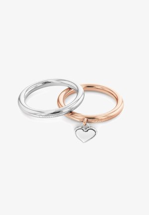 Dos anillos entrelazados: uno de plata y otro de oro rosa. El anillo de plata tiene un acabado liso, mientras que el anillo de oro rosa presenta un pequeño colgante en forma de corazón de plata.
