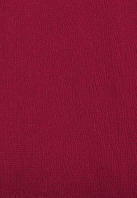 Tissu rouge texturé avec un motif de surface tissé légèrement en relief. La couleur est profonde et solide, offrant un attrait visuel riche.