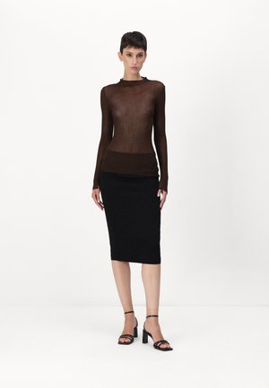 Brun ribbet langermet topp parret med et tettsittende svart kne-langt skjørt, komplementert av svarte stroppehæler. Glatt tekstur, elegant design.