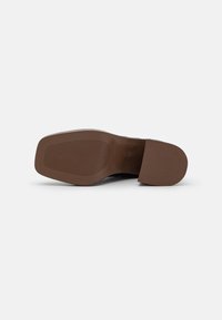 Semelle de chaussure marron au design plat. Présente une texture côtelée pour l'adhérence et des bords lisses. Fabriquée en matériau durable et flexible.