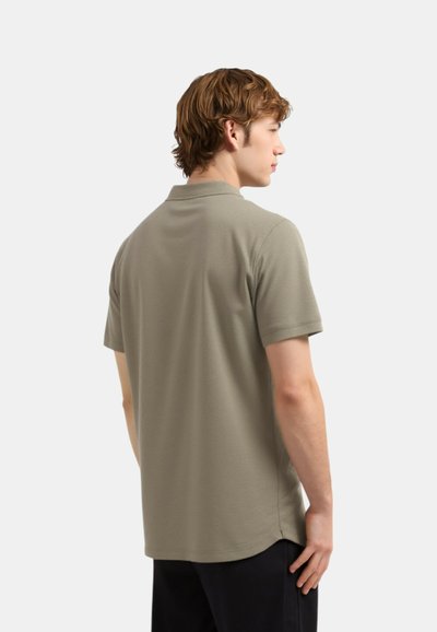 Polo majica s kratkimi rokavi v svetlo olivno zeleni tkanini, z značilnim ovratnikom in ravnim robom, prikazana zadaj.