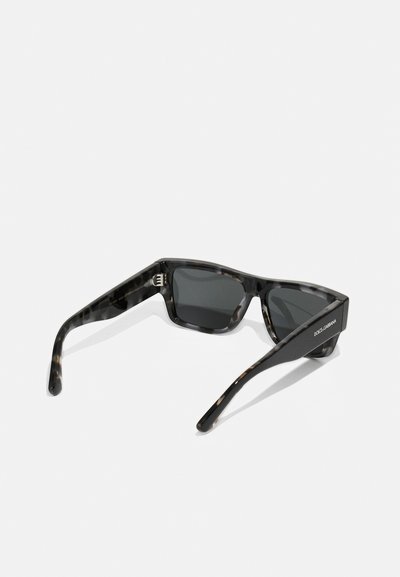 Ochelari de soare din scoică cu lentile închise. Cadru rectangular cu brațe groase. Prezintă o marcă subtilă pe un brat. Textură netedă.