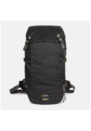 Sort National Geographic- og Eastpak-rygsæk med spænder på stropperne og lynlåslomme foran på en ensfarvet baggrund.