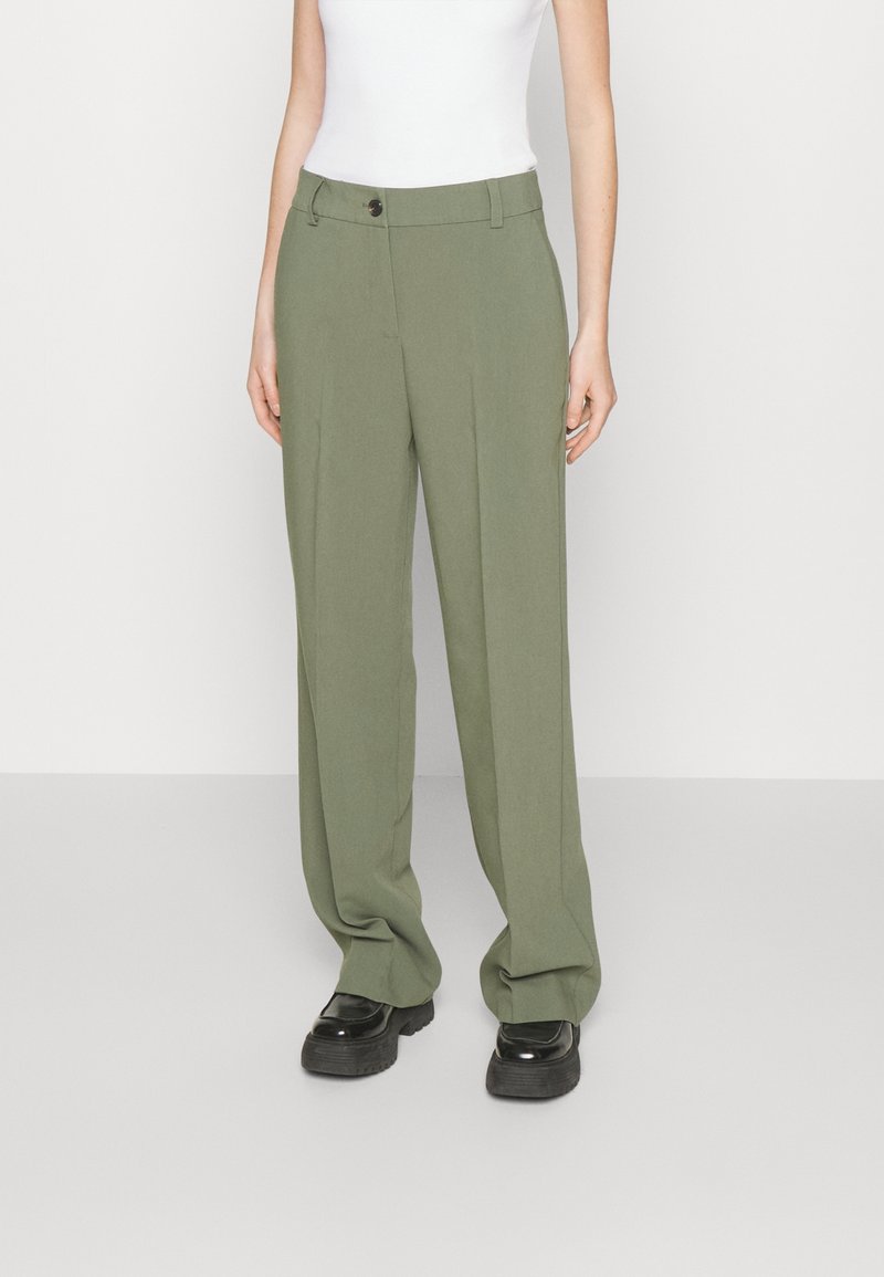 Pantaloni tailorati verde oliva con una vestibilità morbida, dotati di chiusura con bottone e passanti per la cintura. Tessuto liscio con una leggera lucentezza.