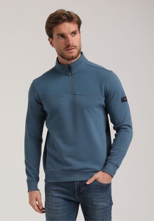 Pullover blu in tessuto liscio, con collo a mezza zip e pannello testurizzato sulla parte anteriore superiore. Polsini e orlo a coste.