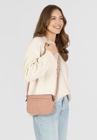 Borsa a tracolla rosa chiaro realizzata in pelle liscia, con chiusura a zip e tracolla regolabile. La borsa è rettangolare con logo impresso.