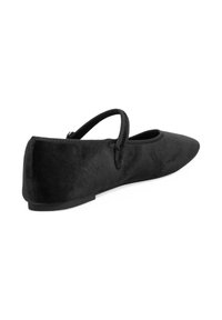 Zapato plano de terciopelo negro con punta afilada y una delgada tira elástica en la parte superior. Presenta una suela baja texturizada y un acabado suave.
