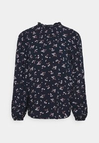 Marinblus med vitt och rosa blommönster, långa puffärmar, rund halsringning med volang och draperad detalj vid axlarna.