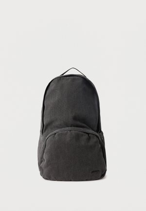 Zwarte stoffen rugzak met één groot hoofdvak, een voorvak met ritssluiting en een draaglus aan de bovenkant, afgebeeld tegen een effen witte achtergrond.