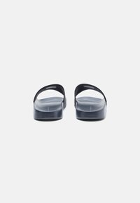 Black silicone flip-flops with a smooth texture, featuring a flat sole and two wide straps extending from the base.