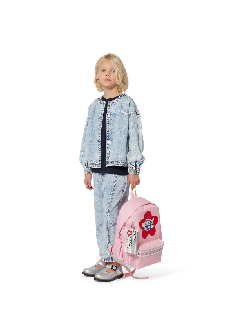 Veste en jean et pantalon bleu clair avec une coupe décontractée. Sac à dos rose avec un logo en forme de fleur rouge et des détails en métal argenté. Chaussures argentées.