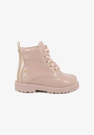Stivaletti alla caviglia in pelle verniciata rosa con punta rotonda, hardware dorato e dettagli a forma di stella sui lati. Progettati con allacciatura frontale e suola testurizzata.