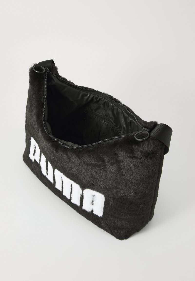 Bolso de mano de piel de pelo sintético negro con cierre de cremallera, que presenta un forro interior y un prominente logo en blanco de "PUMA" en la parte frontal.