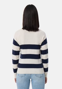 Maglione a righe in crema e blu navy, caratterizzato da righe orizzontali, vita aderente e polsini a coste. Realizzato in materiale morbido e testurizzato.