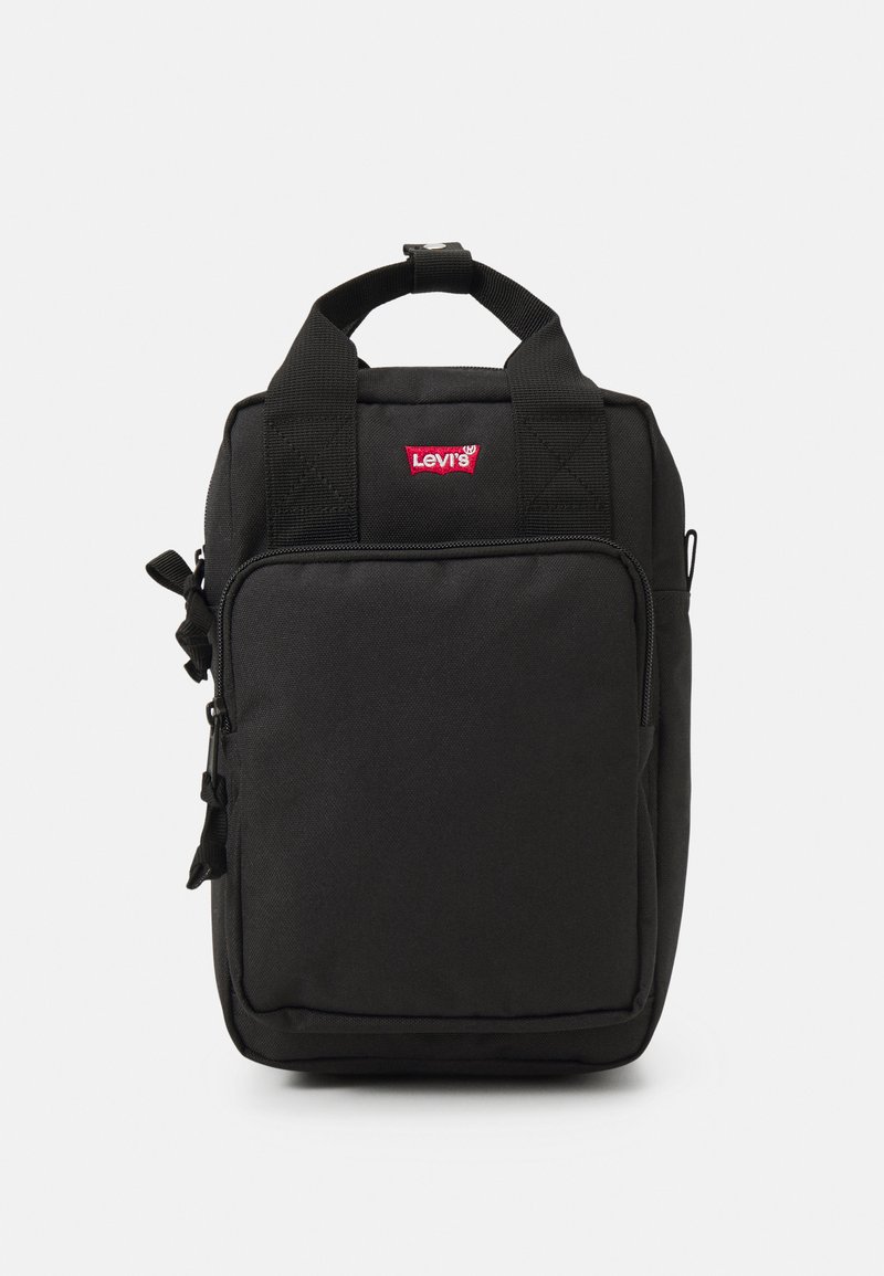 Crni ruksak napravljen od izdržljive tkanine s prednjim džepom na patentni zatvarač, gornjom drškom za nošenje i malim crvenim Levi's logotipom sprijeda.
