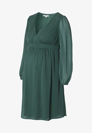 Robe de maternité verte, longueur genou, avec un design croisé, de longues manches transparentes et une ceinture en tissu. Fabriquée dans un matériau léger et texturé.