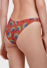 Crvene bikini gaćice s uzorkom navijačkih rekvizita u plavoj i žutoj boji, s teksturiranom površinom i niskim strukom.