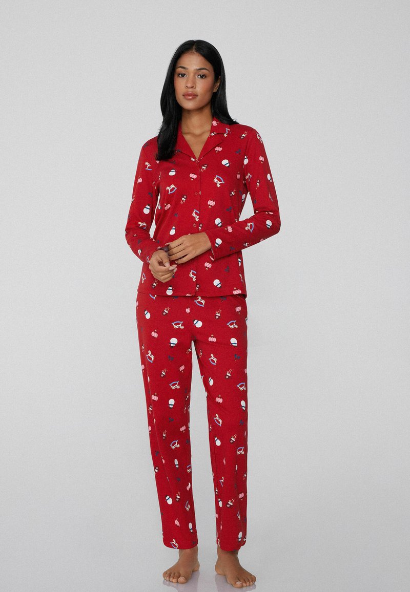 Rode pyjama set met lange mouwen en broek, versierd met een speelse print van vakantie-thema iconen in blauw en wit. Zachte stof.