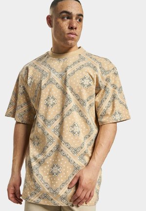 Beige kortermet skjorte med et paisley-mønster i svart og hvitt, med en avslappet passform og rund nakke.